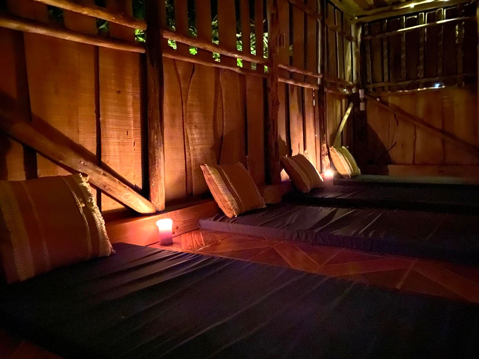 Private retreat room with candlelight and floor seating in a wooden house at Lian House Costa Rica